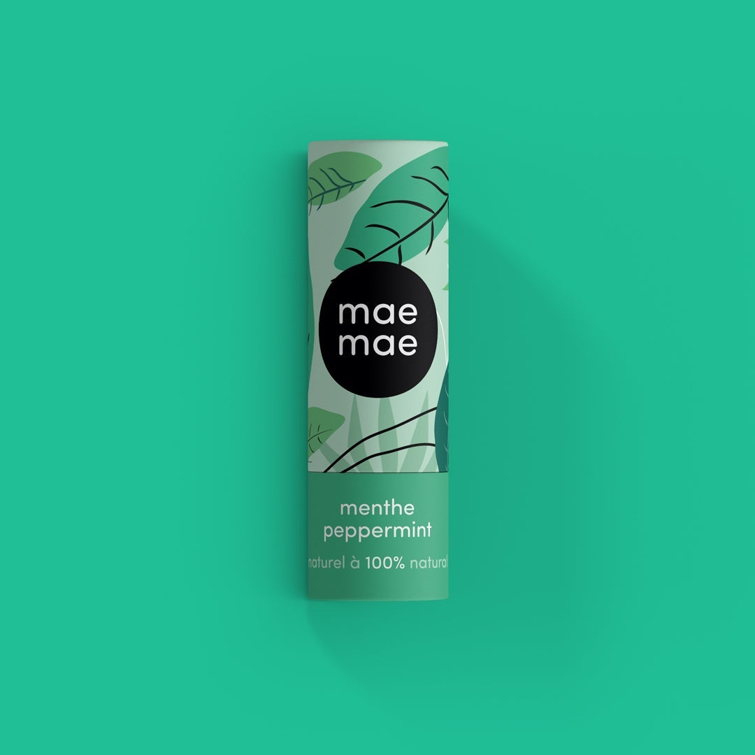 tube de baume à lèvre mae mae menthe avec des feuilles sur fond vert