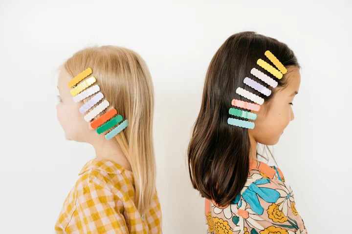 deux filles avec des barettes pinces et clip cheveux de plusieurs couleurs dans leurs cheveux