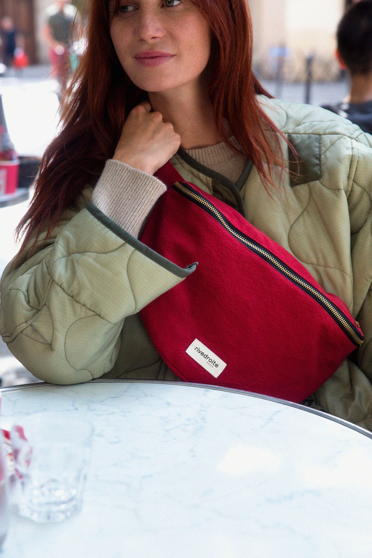 Sac babane custine XL rouge velour rive droite porté en bandouillère sur une femme en manteau